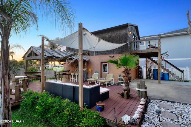 deck at dusk featuring an outdoor hangout area