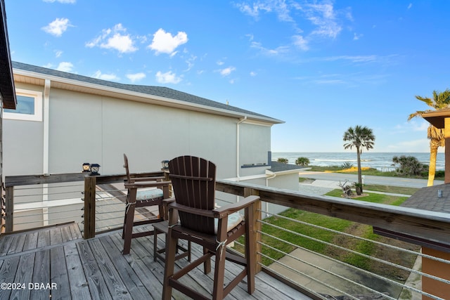 wooden terrace with a water view and a view of the beach