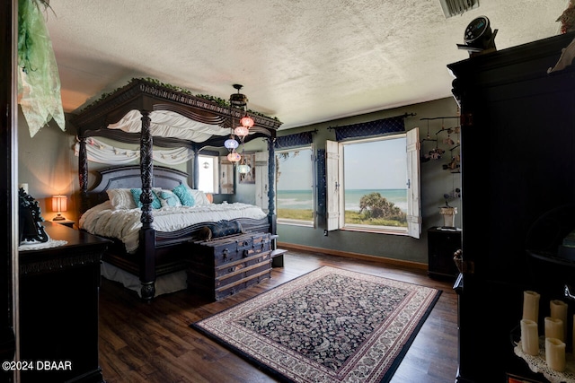 bedroom featuring a textured ceiling and dark hardwood / wood-style flooring