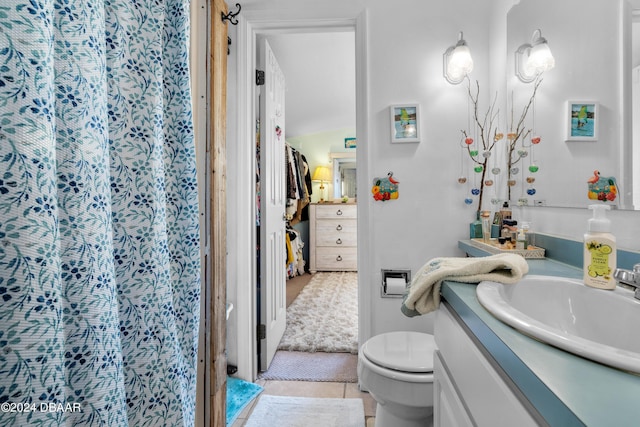 bathroom with toilet, vanity, and tile patterned floors