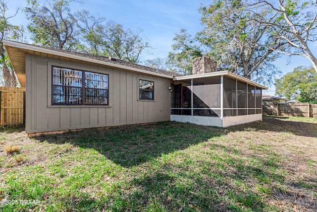 back of property featuring a yard and a sunroom