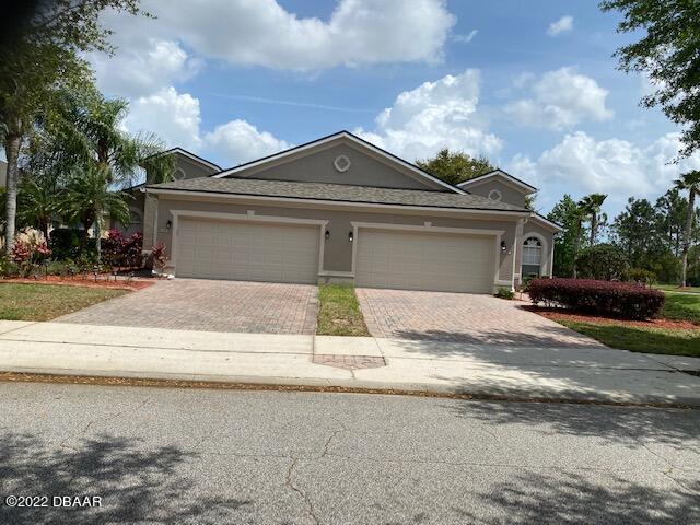 136 Mendoza Cir, Daytona Beach, FL 32124 - view of front of property with decorative driveway, a garage, and stucco siding