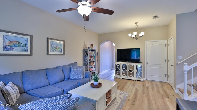 living room with ceiling fan with notable chandelier and light wood-type flooring