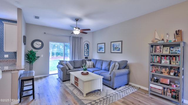 living room featuring light hardwood / wood-style floors and ceiling fan