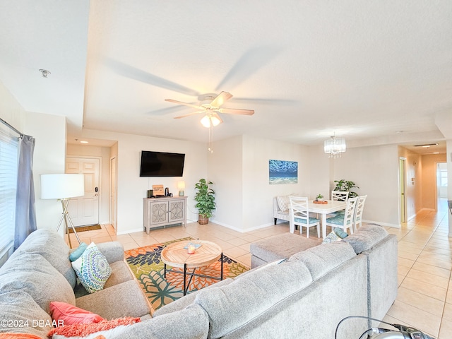 tiled living room featuring ceiling fan with notable chandelier and a healthy amount of sunlight