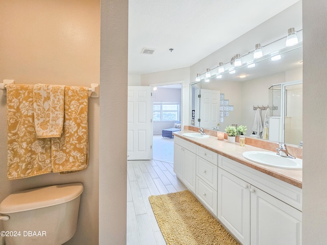 bathroom with an enclosed shower, vanity, and hardwood / wood-style flooring