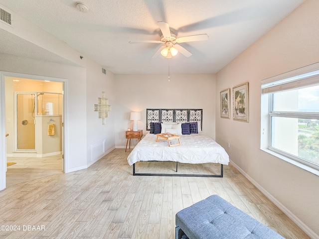 bedroom featuring light wood-type flooring, a textured ceiling, and ceiling fan