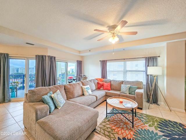 tiled living room featuring a textured ceiling and ceiling fan