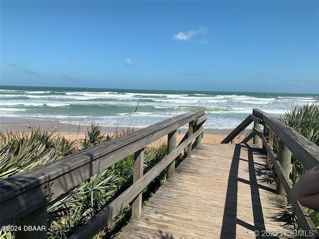 view of property's community featuring a water view and a beach view