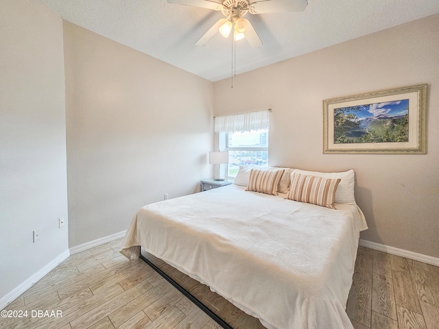 bedroom featuring a textured ceiling, light hardwood / wood-style floors, and ceiling fan