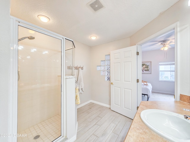 bathroom with hardwood / wood-style floors, walk in shower, a textured ceiling, and vanity