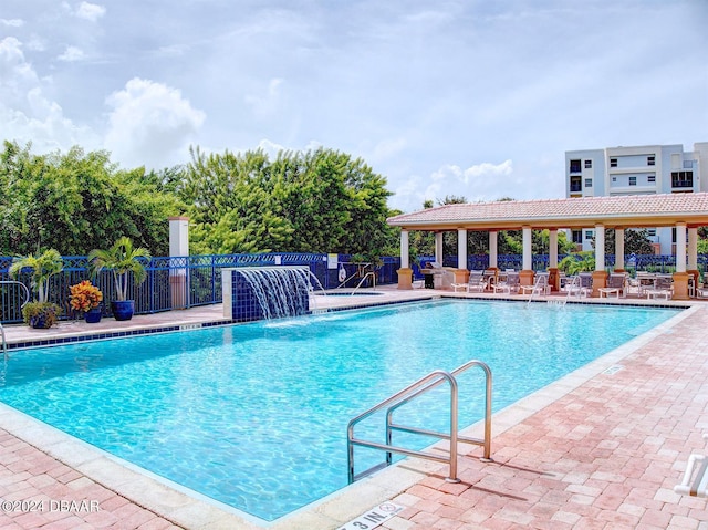 view of swimming pool featuring pool water feature and a patio area