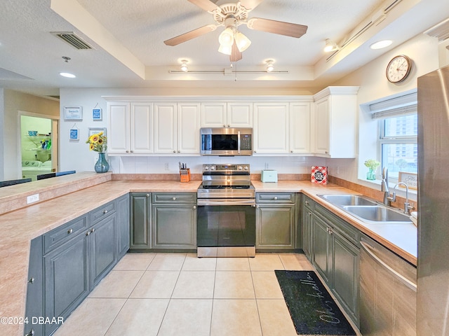 kitchen with white cabinetry, appliances with stainless steel finishes, a textured ceiling, gray cabinets, and sink