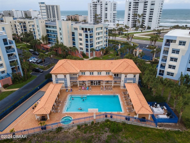 view of swimming pool featuring a water view and a patio