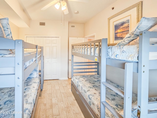 bedroom featuring ceiling fan, a closet, and light wood-type flooring