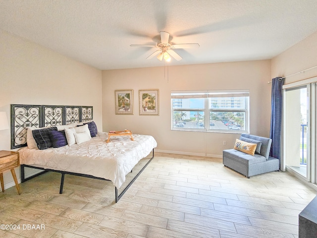 bedroom featuring ceiling fan, a textured ceiling, light wood-type flooring, and access to outside