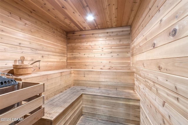 view of sauna featuring wooden ceiling and wooden walls