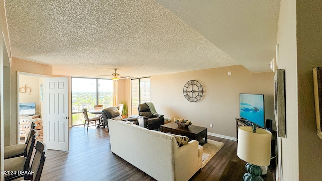 living room with ceiling fan, dark hardwood / wood-style floors, a textured ceiling, and a wall of windows