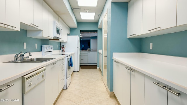 kitchen featuring white cabinetry, sink, and white appliances