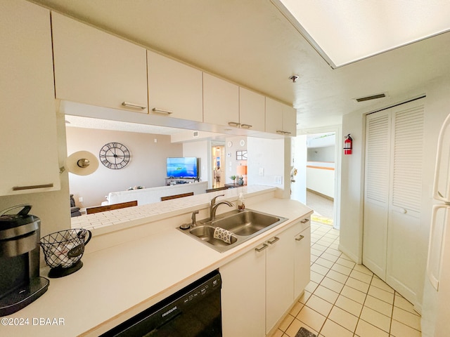 kitchen with light tile patterned flooring, sink, kitchen peninsula, white cabinets, and black dishwasher