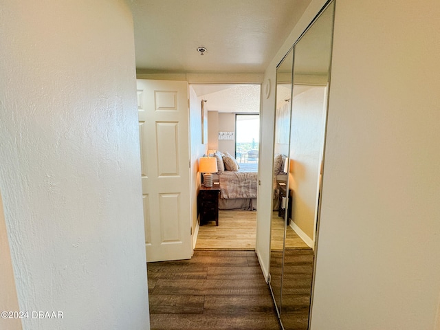 corridor with hardwood / wood-style flooring