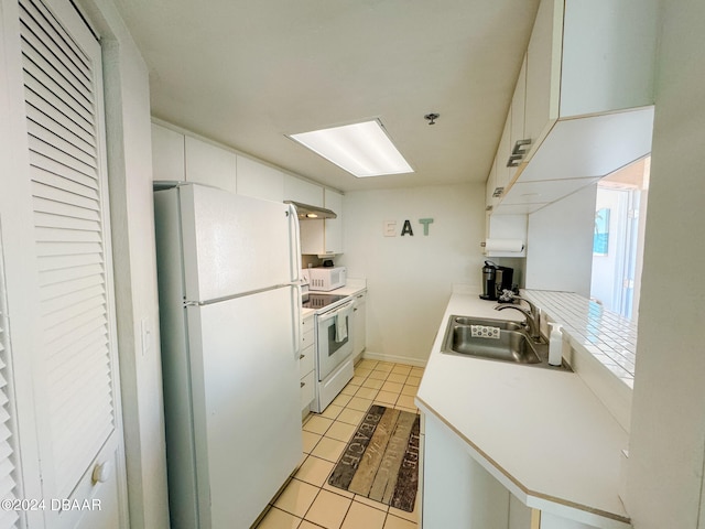 kitchen featuring white cabinetry, sink, kitchen peninsula, light tile patterned floors, and white appliances