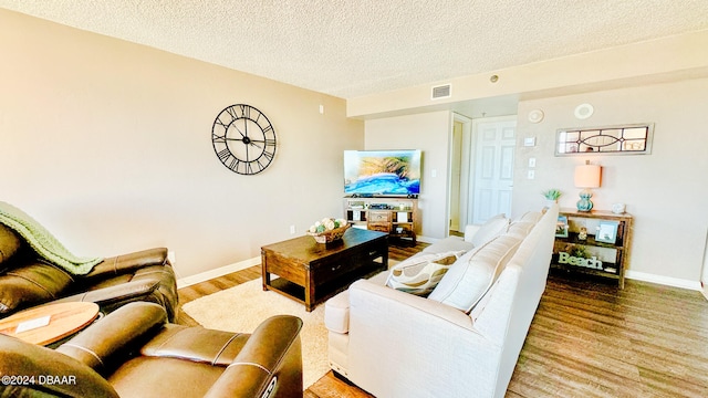 living room featuring hardwood / wood-style flooring and a textured ceiling