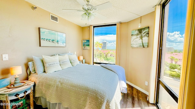 bedroom with dark wood-type flooring, ceiling fan, and multiple windows