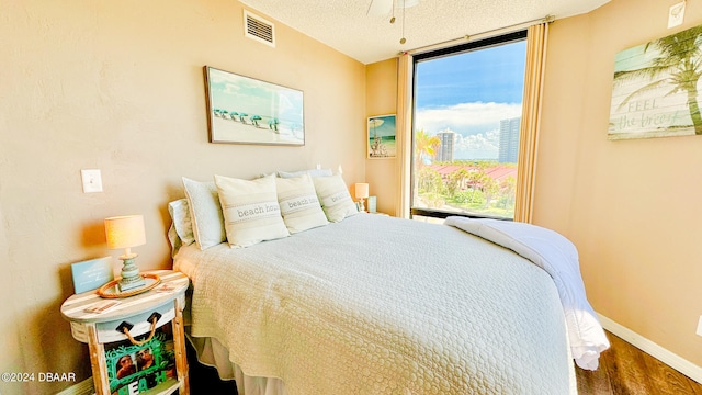 bedroom featuring hardwood / wood-style floors and a textured ceiling