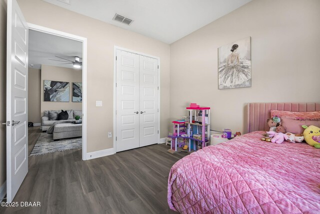 bedroom with lofted ceiling, wood finished floors, visible vents, baseboards, and a closet