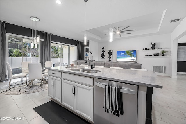 kitchen with visible vents, a raised ceiling, and a sink