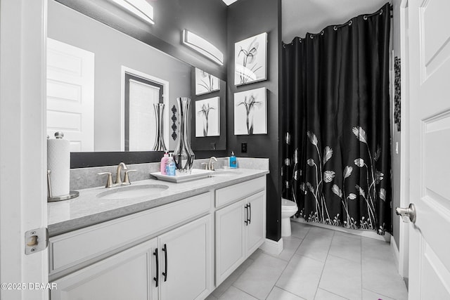 full bath featuring double vanity, tile patterned flooring, a sink, and toilet