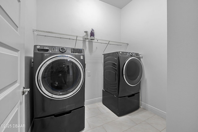 laundry area with laundry area, light tile patterned floors, baseboards, and separate washer and dryer