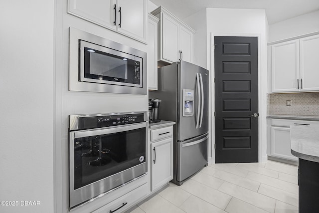 kitchen featuring light countertops, appliances with stainless steel finishes, white cabinetry, and tasteful backsplash