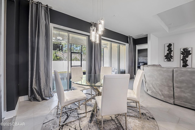 dining area with light tile patterned floors, baseboards, and an inviting chandelier