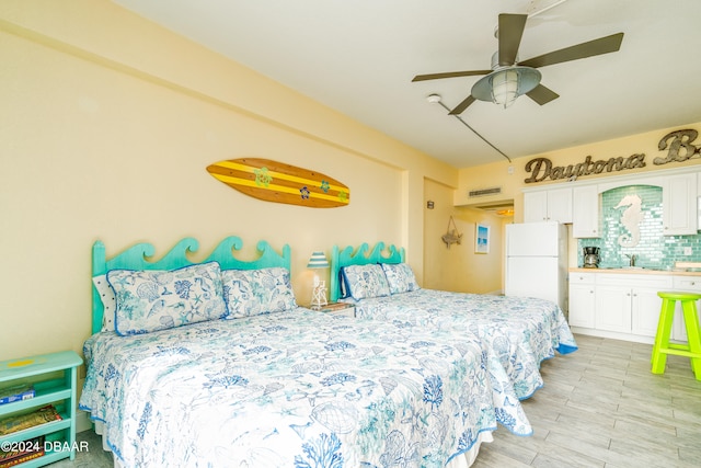 bedroom featuring ceiling fan, sink, and white fridge