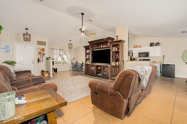 living room featuring lofted ceiling, light tile patterned floors, and ceiling fan