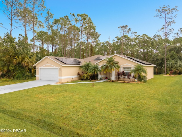 single story home featuring a garage, solar panels, and a front yard