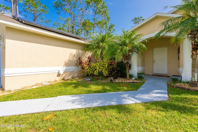 doorway to property featuring a lawn