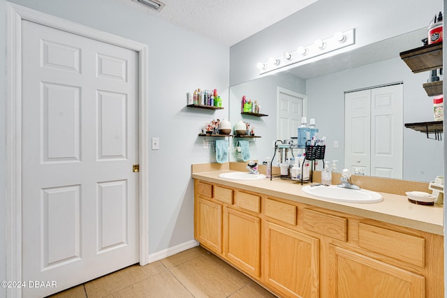 bathroom with vanity, tile patterned floors, and a textured ceiling