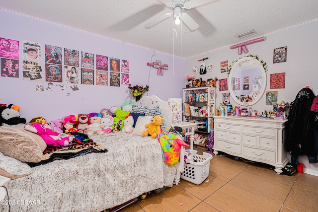 bedroom featuring a textured ceiling, tile patterned flooring, and ceiling fan