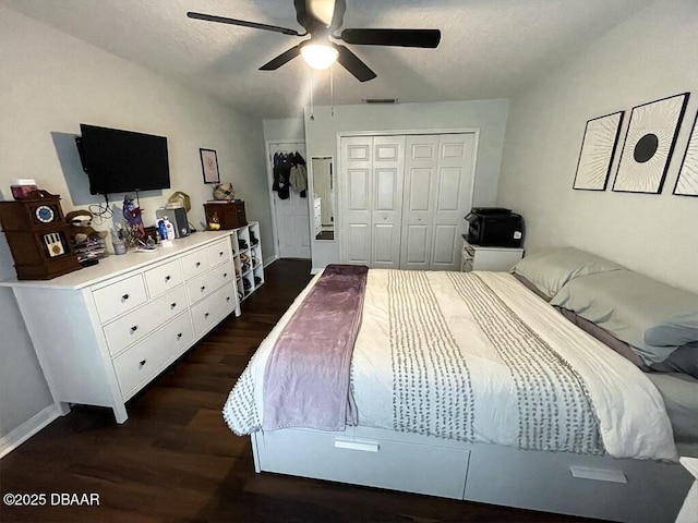 bedroom featuring ceiling fan, a closet, dark hardwood / wood-style flooring, and a textured ceiling