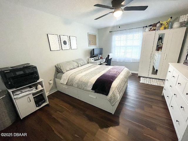 bedroom with ceiling fan, dark hardwood / wood-style flooring, and a textured ceiling