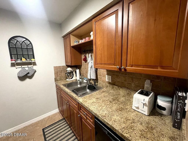 kitchen featuring light tile patterned flooring, decorative backsplash, sink, and light stone counters