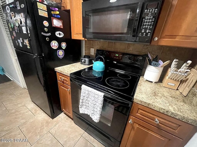 kitchen with light tile patterned flooring, tasteful backsplash, and black appliances