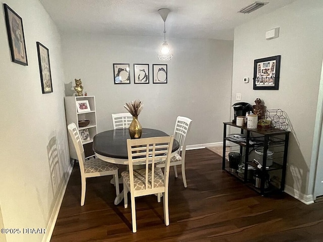 dining space with dark hardwood / wood-style flooring