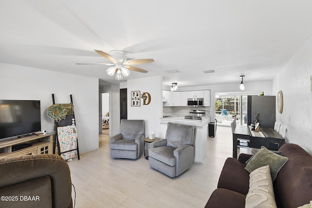 living area featuring ceiling fan and light wood finished floors