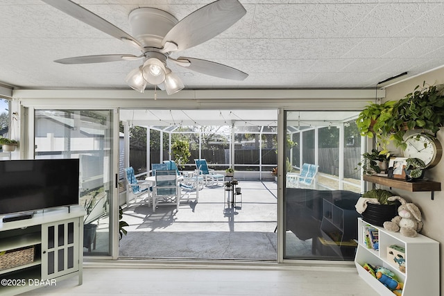 sunroom / solarium featuring plenty of natural light and a ceiling fan