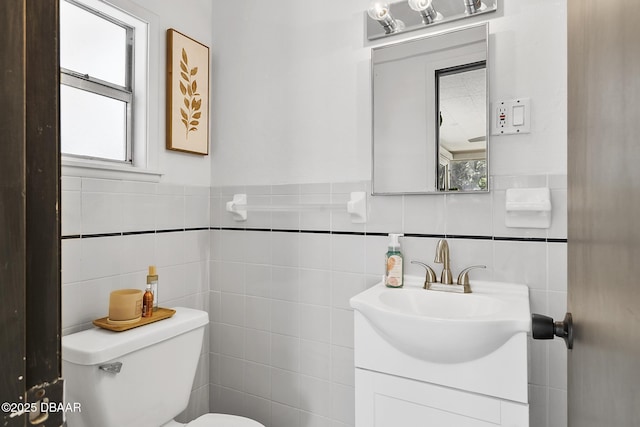 bathroom with tile walls, vanity, and toilet