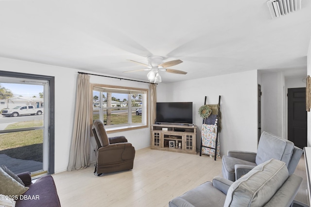 living area with ceiling fan, wood finished floors, and visible vents